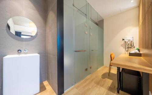a bathroom with a shower and a table and a mirror at The Line Hotel in Yangpyeong