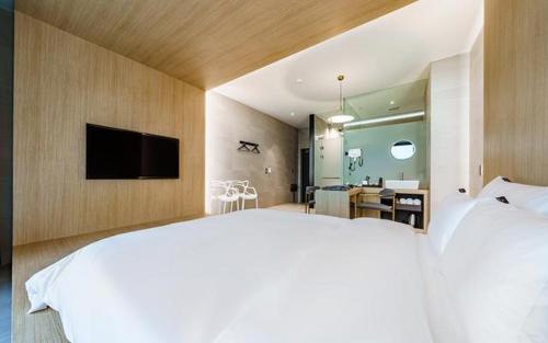 a bedroom with a large bed and a television on a wall at The Line Hotel in Yangpyeong