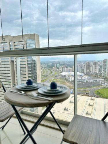 a table in a window with a view of a city at Aconchego dentro do Shopping em Brasília in Brasilia