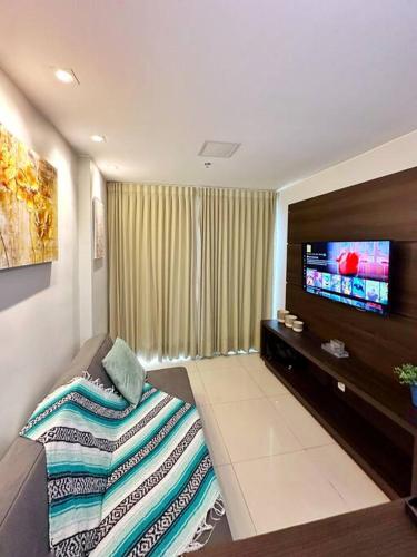a living room with a couch and a flat screen tv at Aconchego dentro do Shopping em Brasília in Brasilia