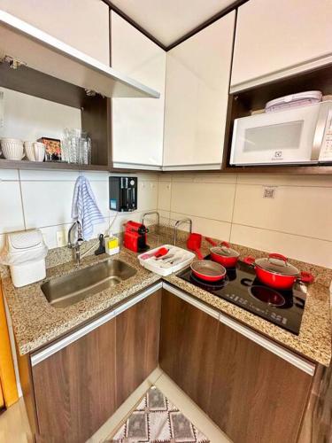 a kitchen with a sink and a stove top oven at Aconchego dentro do Shopping em Brasília in Brasilia