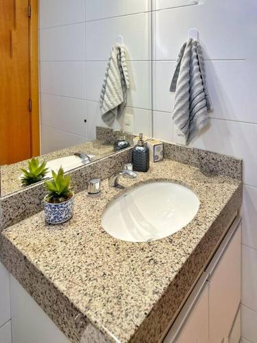 a bathroom counter with a sink and a mirror at Aconchego dentro do Shopping em Brasília in Brasilia