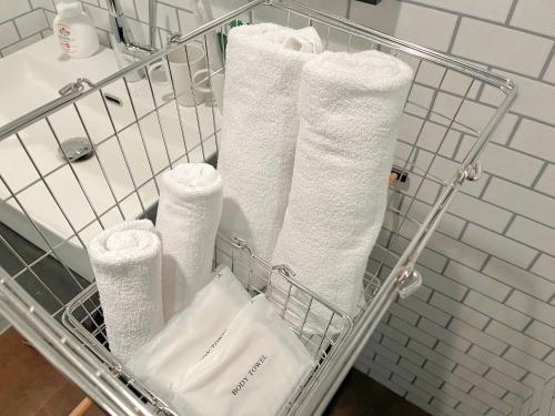 a towel rack with white towels in a bathroom at Book Tea Bed SHINJUKU-GYOEN in Tokyo