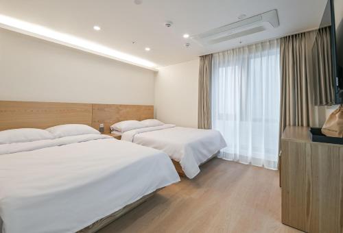 a hotel room with two beds and a television at Seoul N Hostel in Seoul