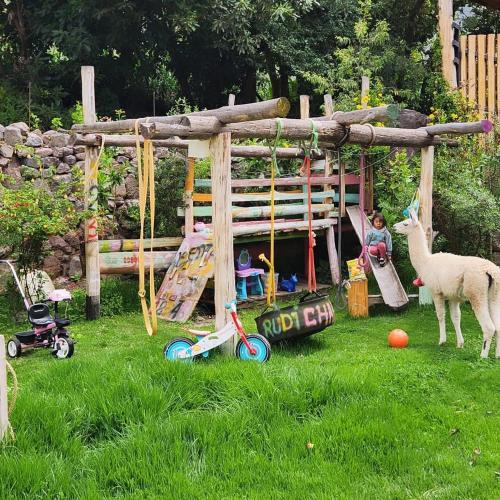 a pretend play area with a playground with a sheep at Spirit Of The River Lodge in Cusco