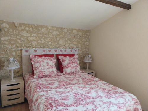 a bedroom with a bed with a pink comforter and two lamps at Gîte Eymet, 3 pièces, 4 personnes - FR-1-616-247 in Eymet