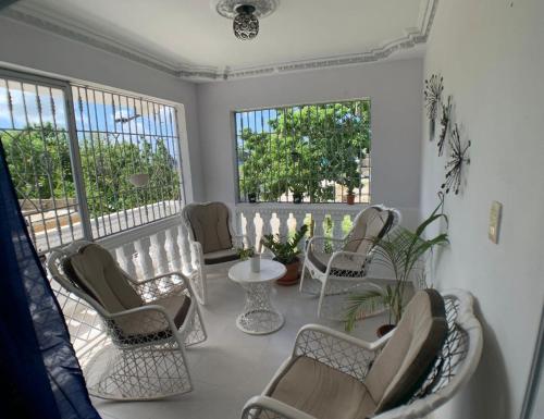 Zimmer mit Stühlen, einem Tisch und Fenstern in der Unterkunft Sandy Airbnb in La Caleta