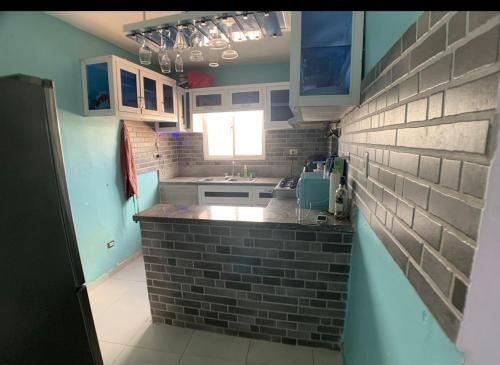 cocina con paredes azules y pared de ladrillo en Sandy Airbnb, en La Caleta