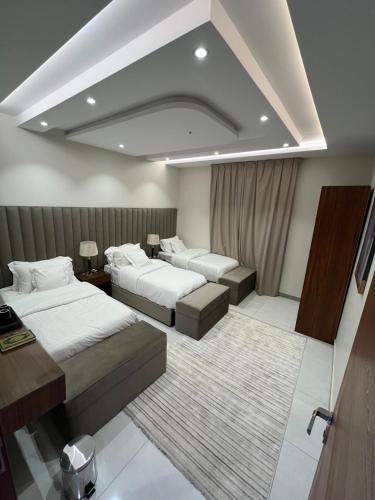 a hotel room with two beds and a couch at شقة فندقية راقيه ثلاث غرف نوم in Jeddah