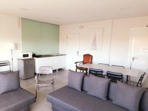 a living room with a couch and a table with chairs at TOLETUM low cost LOFTS diáfanos o 2dormitorios PARKING Municipal Gratis al aire libre a 100m in Toledo