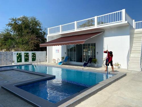 un homme debout dans une piscine à côté d'une maison dans l'établissement Mangroves & Sandbar Private Resort, à Calatagan