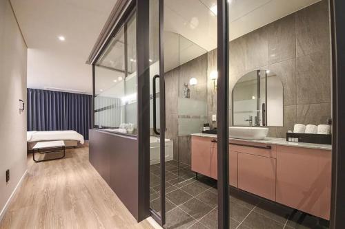 a bathroom with a tub and a sink and a mirror at No25 Hotel Yangpyeong Seojong in Yangpyeong