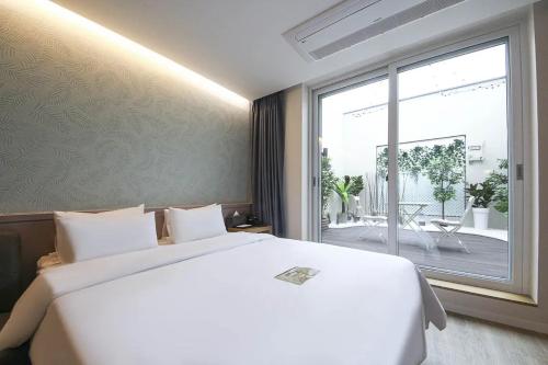1 dormitorio con cama blanca y ventana grande en No25 Hotel Yangpyeong Seojong en Yangpyeong