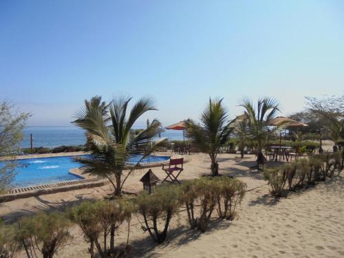 a resort with a pool and palm trees on the beach at Balihai Bungalows in Canoas De Punta Sal