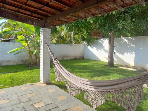 a hammock under a pergola in a yard at Casa confortável em Estancia in Estância