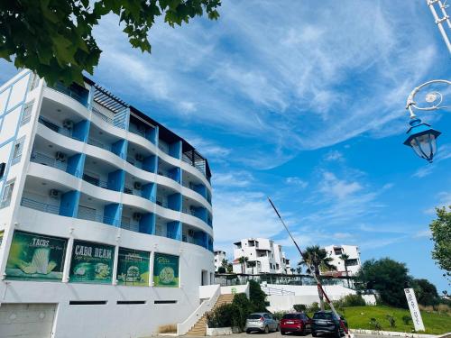 a white building with cars parked in front of it at Appart-Hotel cabo negro in Cabo Negro