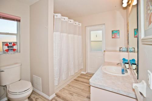 a white bathroom with a toilet and a sink at Classic Floridian Oasis w/Pool in North Port