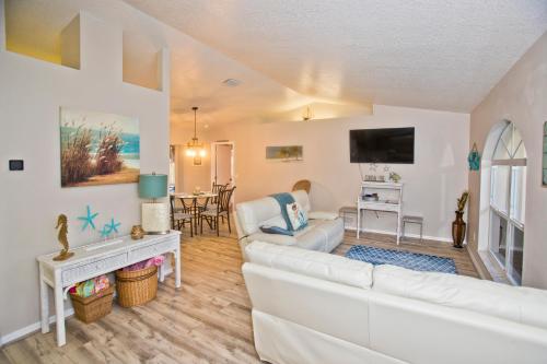 ein Wohnzimmer mit einem weißen Sofa und einem TV in der Unterkunft Classic Floridian Oasis w/Pool in North Port