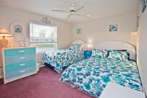 1 Schlafzimmer mit 2 Betten, einer Kommode und einem Fenster in der Unterkunft Classic Floridian Oasis w/Pool in North Port