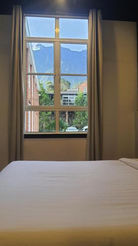 a bedroom with a bed and a large window at H Benjamin Residence in Kundasang