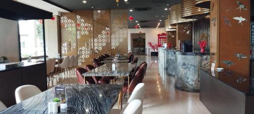 a dining room with tables and chairs in a restaurant at Grand Kolopaking Hotel in Kebumen