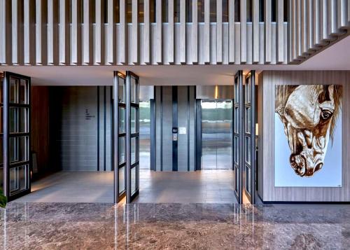 a lobby with a picture of a horse on the wall at The Park Nine Hotel Suvarnabhumi - Free BKK Airport Shuttle in Lat Krabang