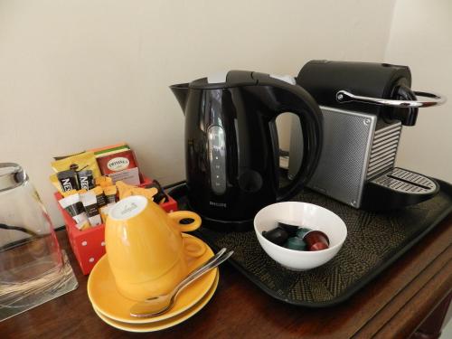 a tray with a coffee maker and a tea kettle on a table at B&B Sombre di Kabana in Willemstad