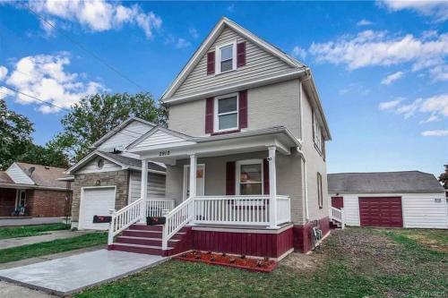 a white house with a red and white porch at Comfortable getaway Single bedroom full apartment in Niagara Falls