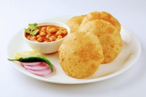 a plate of food with biscuits and a bowl of beans at Shree Nanda Guest House in Varanasi