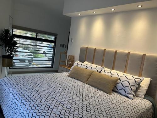 a bedroom with a large bed and a window at Suite Mirador Deluxe in Chihuahua