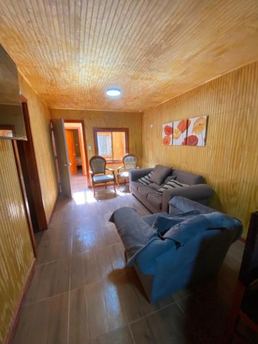 a living room with a couch and a table and chairs at Hostal Coronel Riffo in Coronel