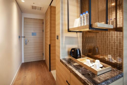 a kitchen with a counter with a sink and a door at Crown Park Hotel Seoul Myeongdong in Seoul