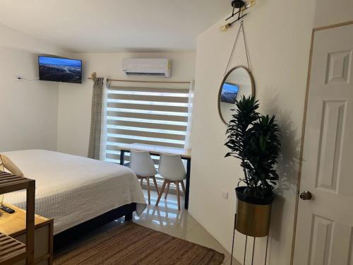 a bedroom with a bed and a table and a mirror at Suite Mirador Deluxe in Chihuahua