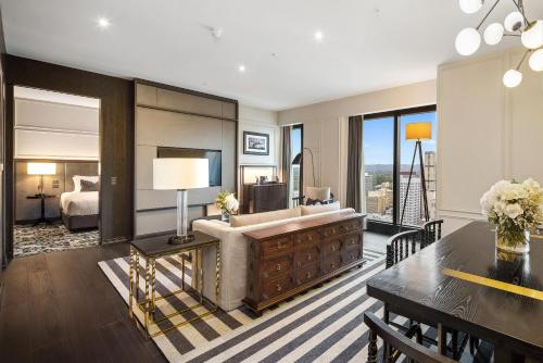 a living room with a couch and a bed and a table at Sofitel Adelaide in Adelaide