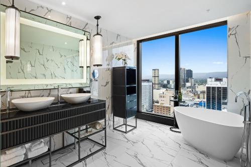 a bathroom with two sinks and a large window at Sofitel Adelaide in Adelaide