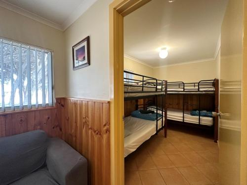 a room with two bunk beds and a couch at Ceduna Shelly Beach Caravan Park in Ceduna