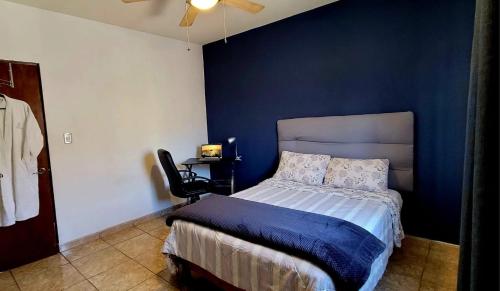 - une chambre avec un lit et un mur bleu dans l'établissement Casa Arboleda, à Saltillo