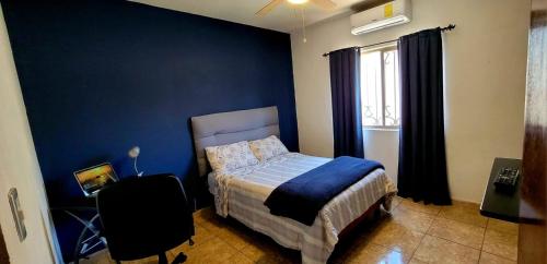 - une chambre avec un lit et un mur bleu dans l'établissement Casa Arboleda, à Saltillo