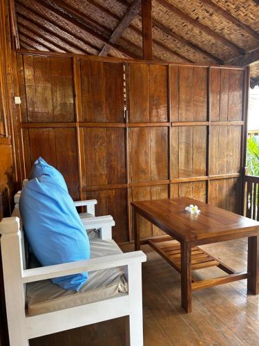 Habitación con mesa, cama, mesa y banco. en Unzipp Bungalows Gili Air en Gili Air