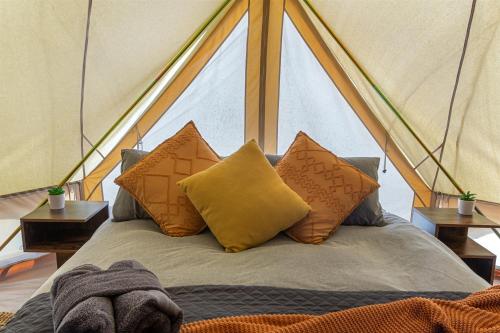 a bed with four pillows in a tent at Forrest Holiday Park in Forrest