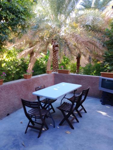 a table and chairs sitting on a patio with a palm tree at Riad Nizwa in Nizwa