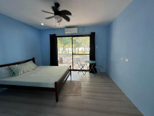 布桑加的住宿－Magalong Villa at Holy Land in Busuanga，一间卧室配有一张床和吊扇