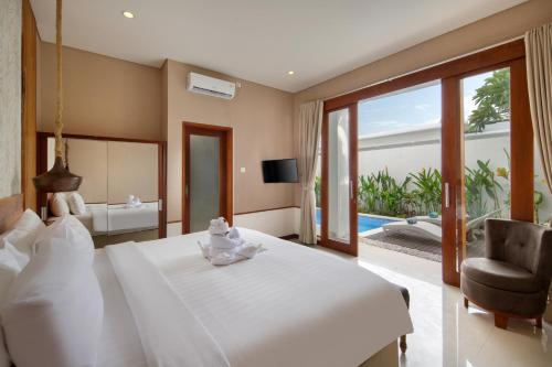 a bedroom with a large white bed and a living room at The Luxury Collection, Monaco Blu in Seminyak
