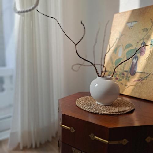 a white vase sitting on top of a dresser at Soban Stay in Busan