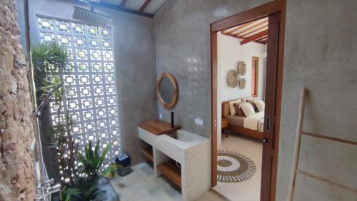 uma casa de banho com um lavatório, um espelho e uma cama em Karyana Villa 1 em Kuta