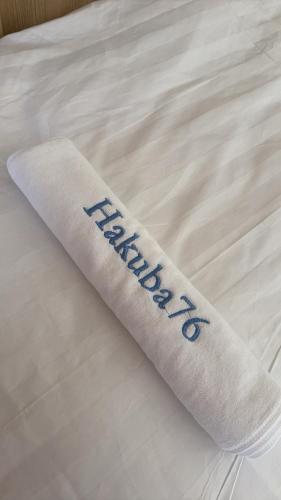 a white sock with the word malaria on a bed at HAKUBA76 in Hakuba
