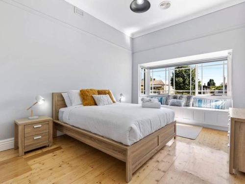 a white bedroom with a large bed and a window at NEW! Stunning 4BR Cottage In The Heart Of Ballarat - PET FRIENDLY & FAST WIFI in Ballarat