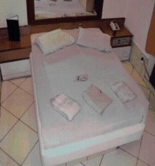 uma cama branca com duas almofadas num quarto em Lips Motel (Adult Only) no Rio de Janeiro