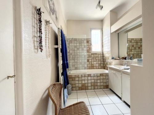 une salle de bain avec une baignoire et un lavabo dans l'établissement Appartement F4 Carnon avec terrasse, parking, climatisation, wifi, accès plage - FR-1-715-92, à Mauguio