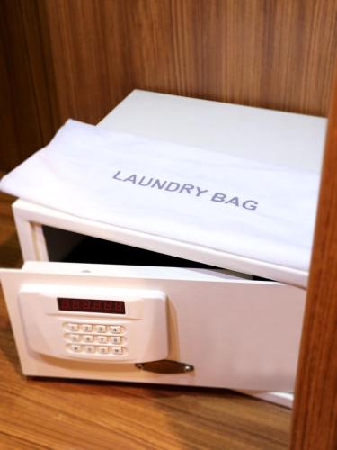 a white laundry bag sitting on top of a microwave at Hotel Santika Premiere Semarang in Semarang